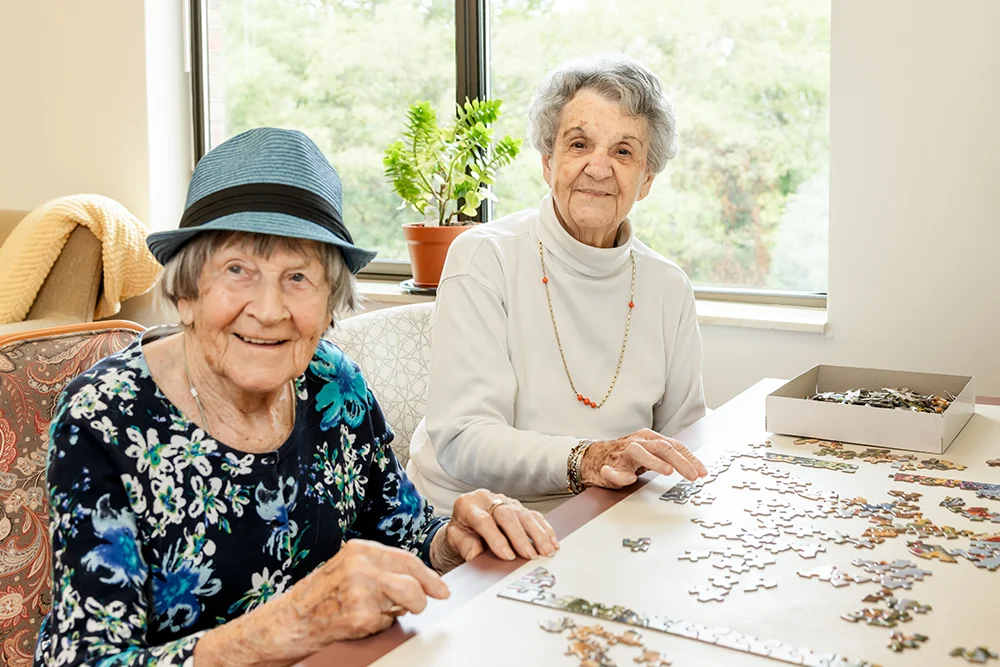 two woman making a puzzle at Sycamore Glen retirement community
