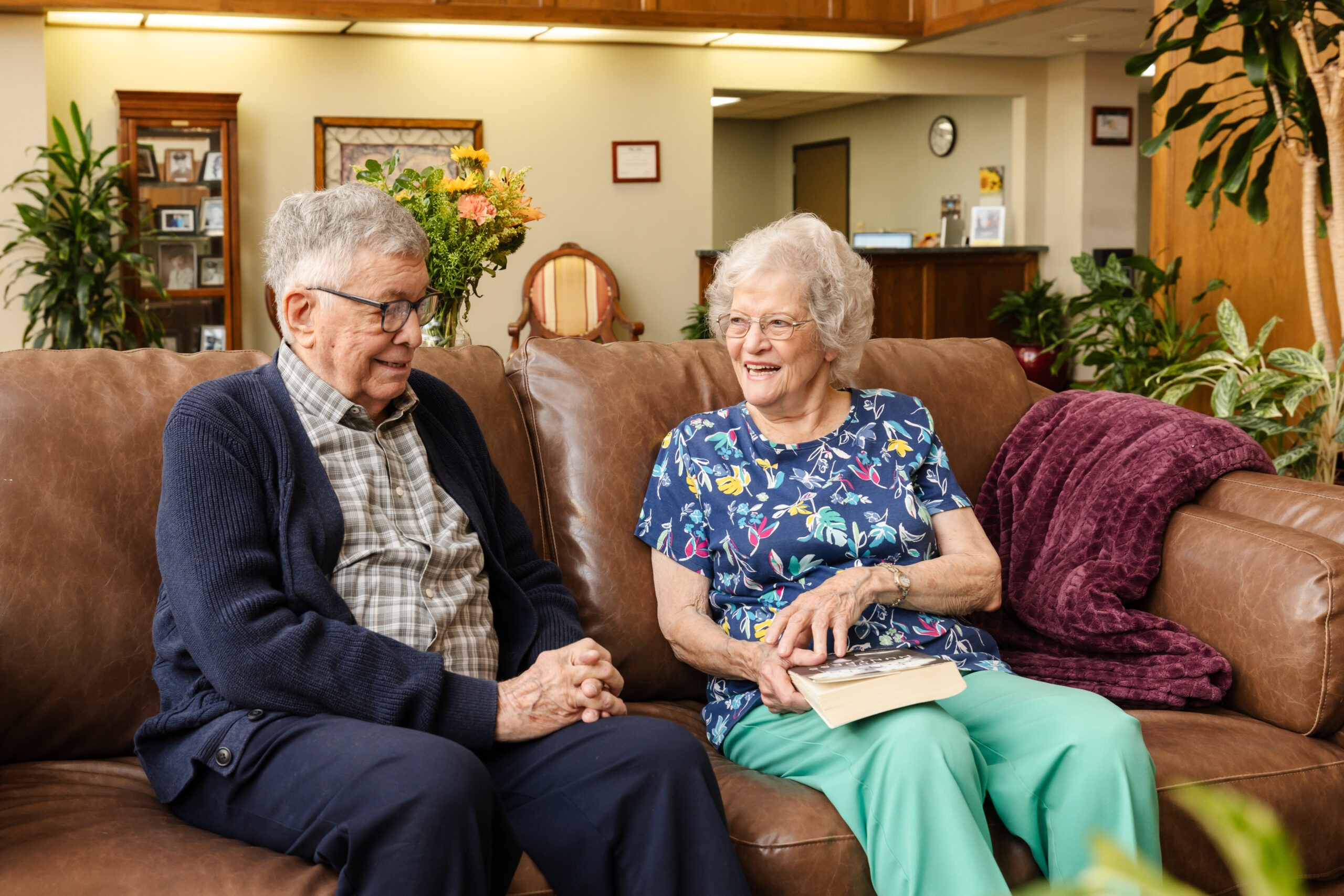 older man and women sitting on couch in lobby